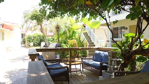 An outdoor patio with wicker furniture, a grill, and a water feature.