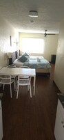A room with a bed, a desk, and chairs.