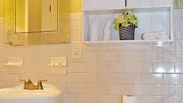 A bathroom with a white sink, a toilet, and a mirror with lights.