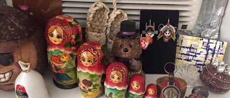 A collection of Russian Matryoshka dolls, a teddy bear, a white teapot, and various decorative items.