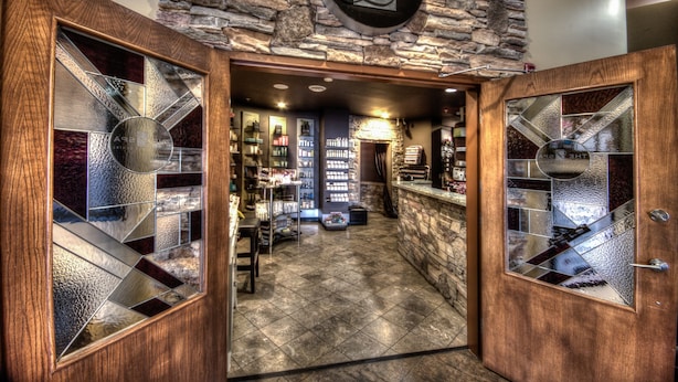 A spa entrance with a stone wall and a sign reading "The L Spa". - Podollan Inn & Spa Grande Prairie (Grande Prairie)