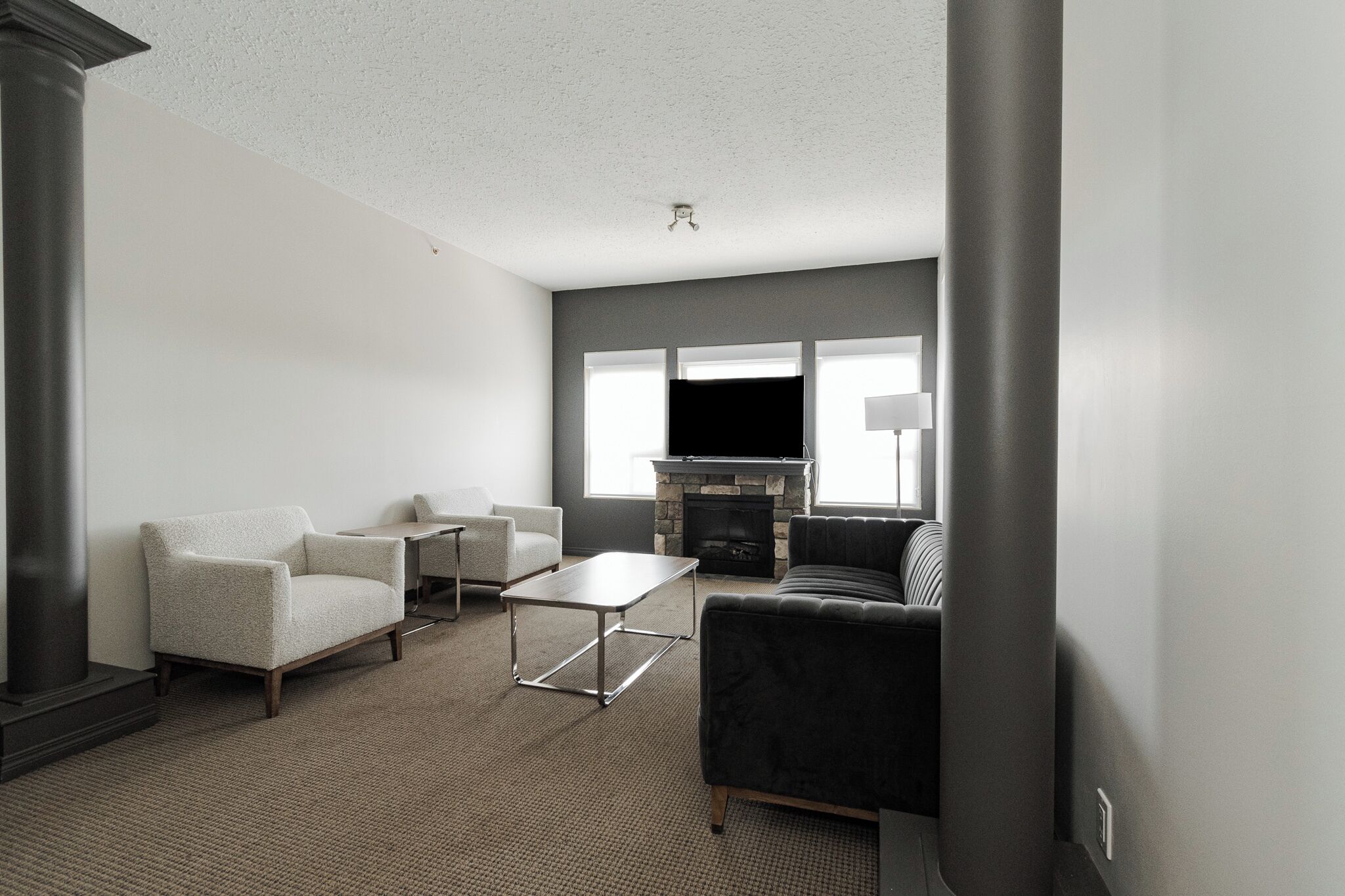 A modern living room with a fireplace, a sofa, armchairs, and a coffee table.