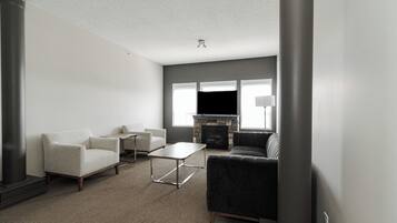 A modern living room with a fireplace, a sofa, armchairs, and a coffee table.
