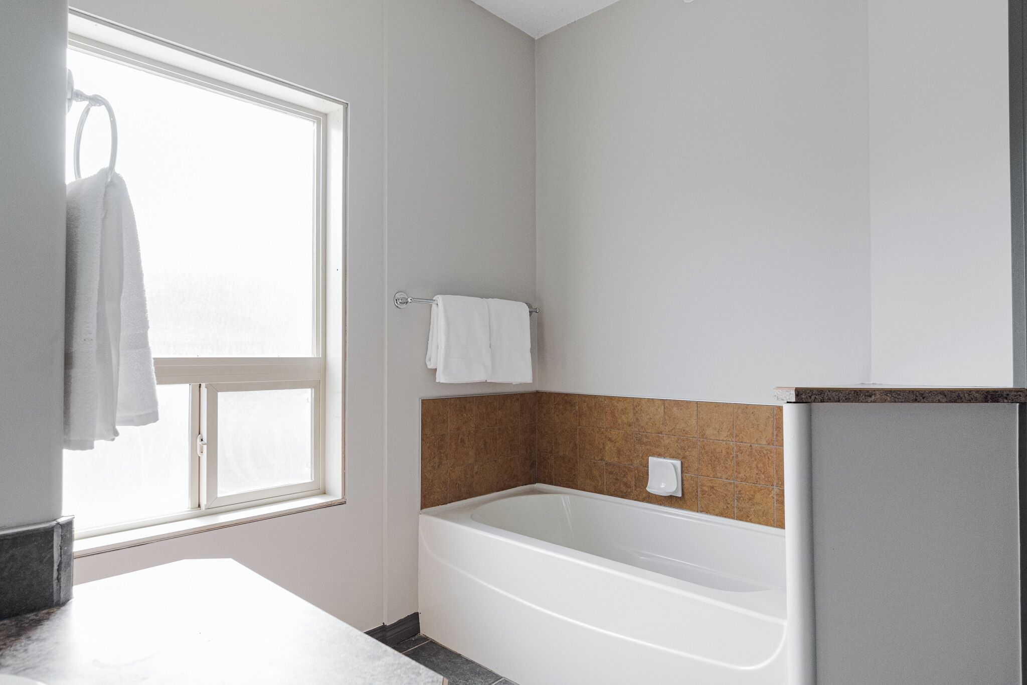 Un bagno con una vasca, una finestra e un portascopevoli.