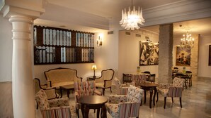 Un hall con candelabro, decoración de pared con diseño y varias zonas de estar.