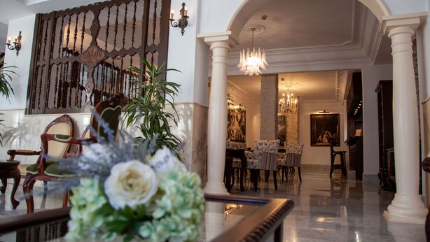 Un hall con una recepción, un comedor y una escalera.