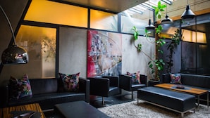 Un salon moderne avec un canapé, des fauteuils, une table basse et une grande fenêtre donnant sur un beau paysage.
