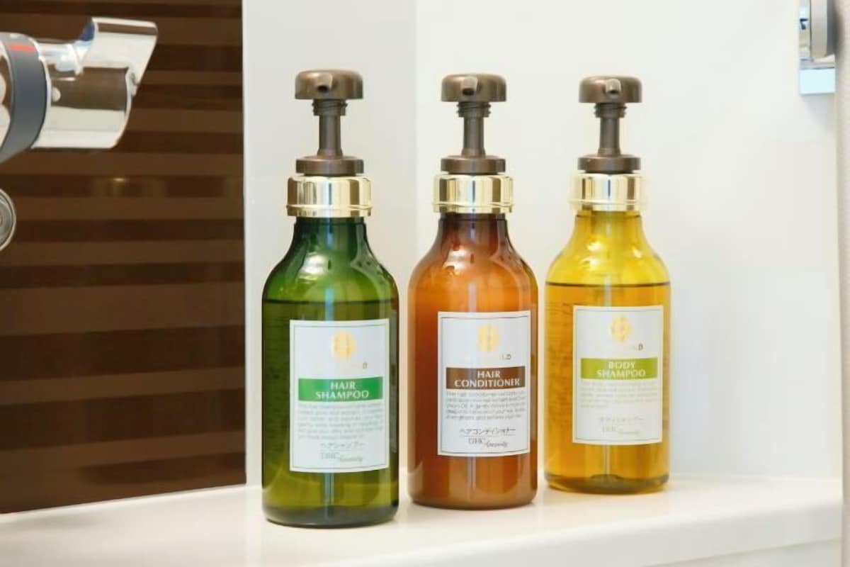 Three bottles of hair care products on a shelf.