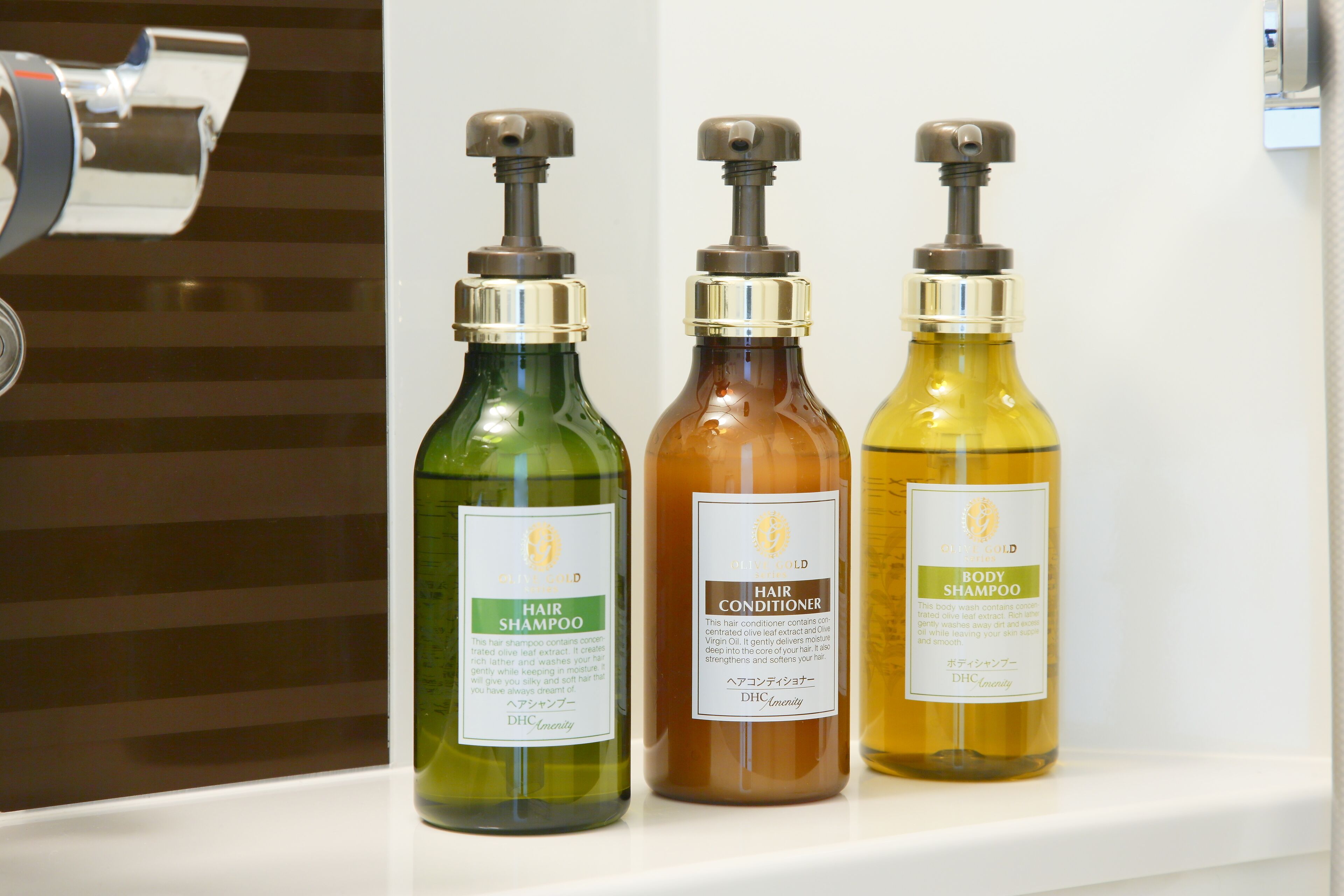 Tres botellas de productos para el cuidado del cabello sobre una estantería.