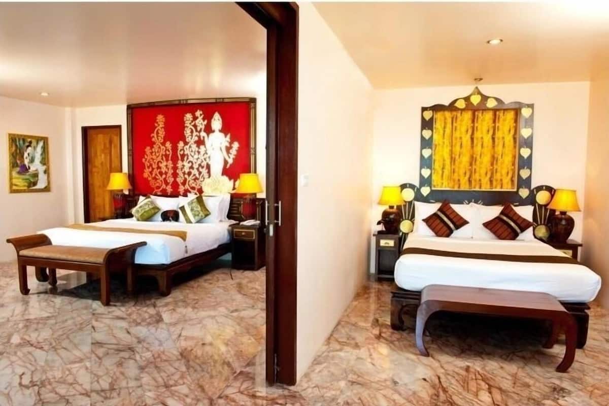 Een hotelkamer met twee bedden, een rode decoratieve paneel en een gele behang met patroon.