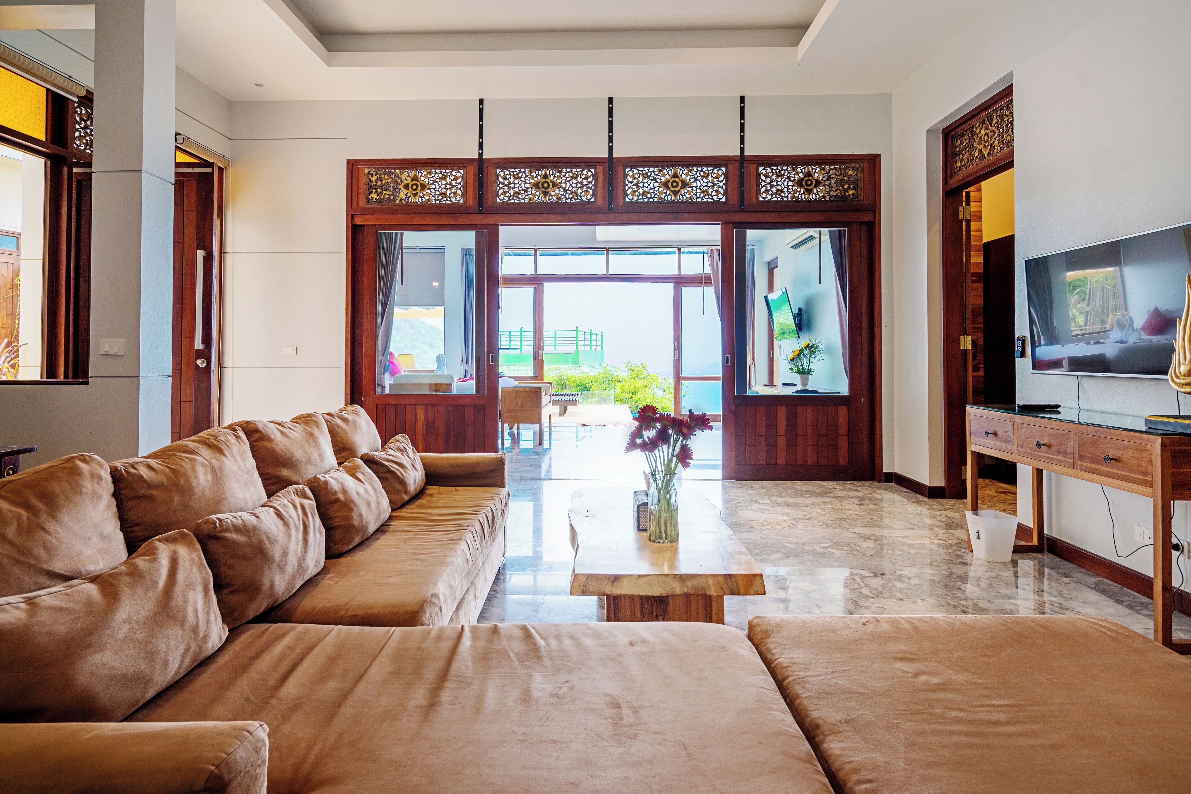 A spacious living room with a large sofa, a coffee table, and a TV.