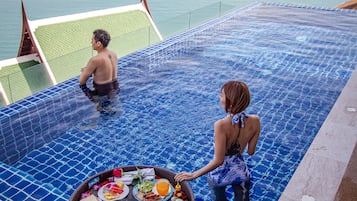 Relax by the ocean-view pool, surrounded by a tiled deck and a convenient poolside dining area.