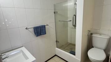 Een badkamer met douche, toilet, wastafel en een handdoekrek.