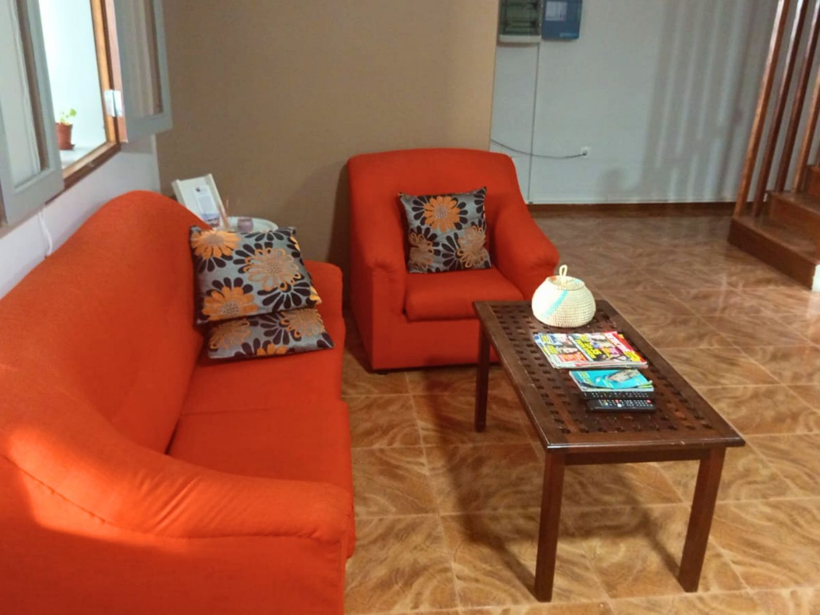 Ein Wohnzimmer mit einer Couch, einem Sessel und einem Couchtisch.