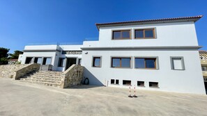 A modern two-story building with a stone staircase leading to the entrance.