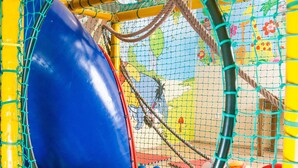 A playground with a netted ball pit and a large blue ball. - JollyKop (Raška)