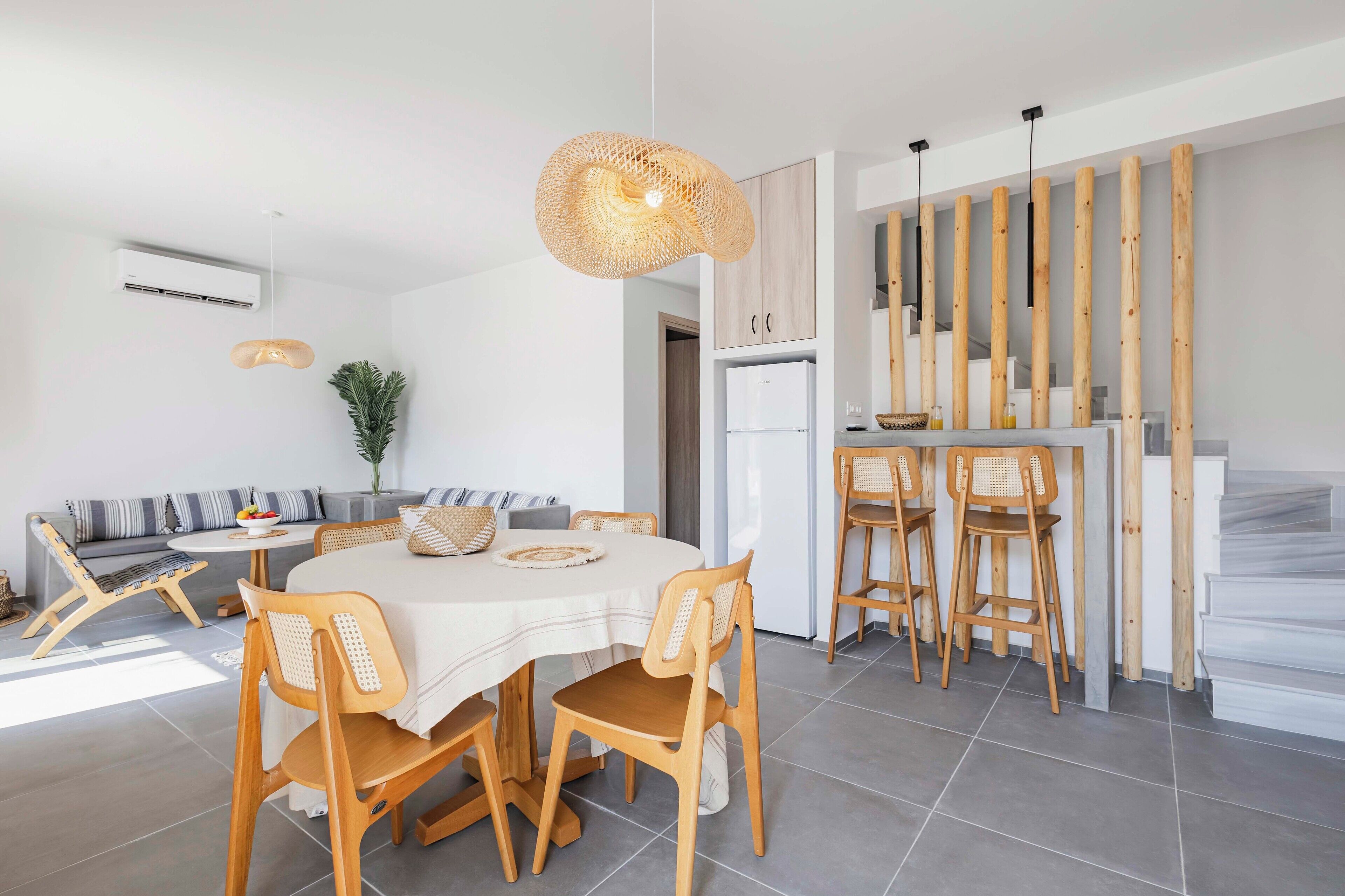 Una cocina moderna con una isla central, sillas de madera y una mesa de comedor.