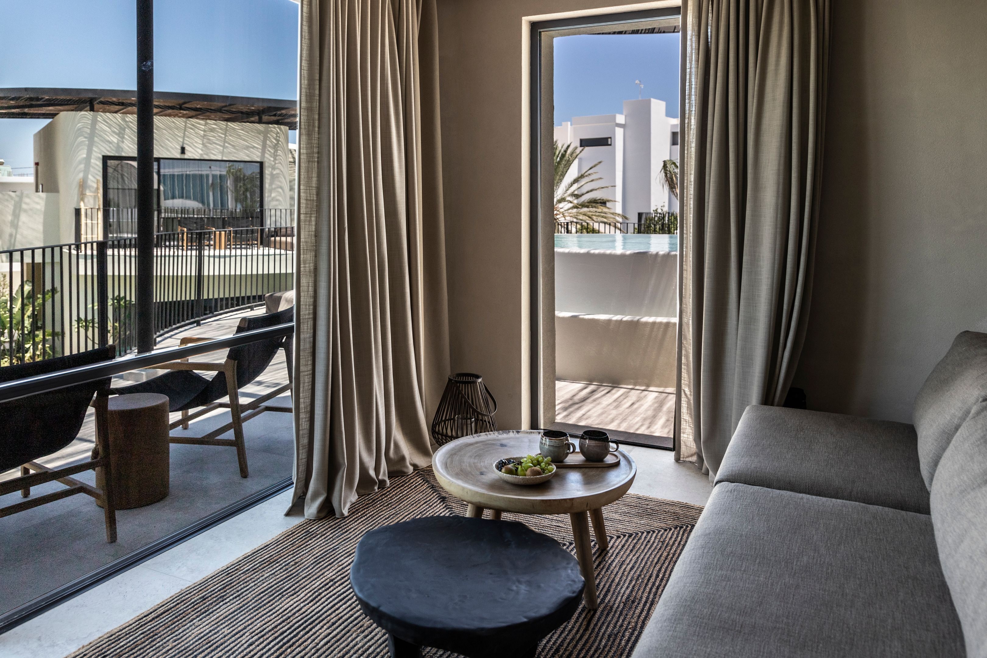 A balcony with a sofa, a small round table, and a chair.