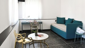 Una habitación moderna con sofá, una mesita y dos sillas.