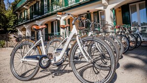 A row of bicycles parked in front of a building with a balcony and a window with green shutters. - Villa Sylva & Spa (Sanremo)