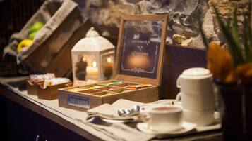 A breakfast bar with a variety of food items, a candle, and a chalkboard with writing.