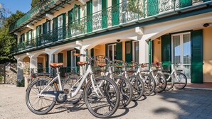 A row of bicycles parked in front of a building with green shutters and ornate balcony railings. - Villa Sylva & Spa (Sanremo)