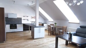 Um apartamento tipo loft moderno, com cozinha, sala de jantar e área de estar.
