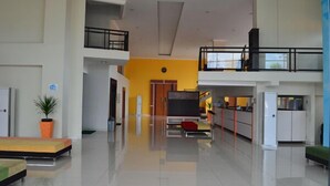 A spacious, modern interior with a high ceiling, a central seating area, and a kitchen on the right. - EDU Hostel (Yogyakarta)
