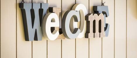 Pared de madera con la palabra "Welcome" en letras tridimensionales grandes.