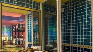 Un baño con un espejo grande, un lavabo y zona de ducha.