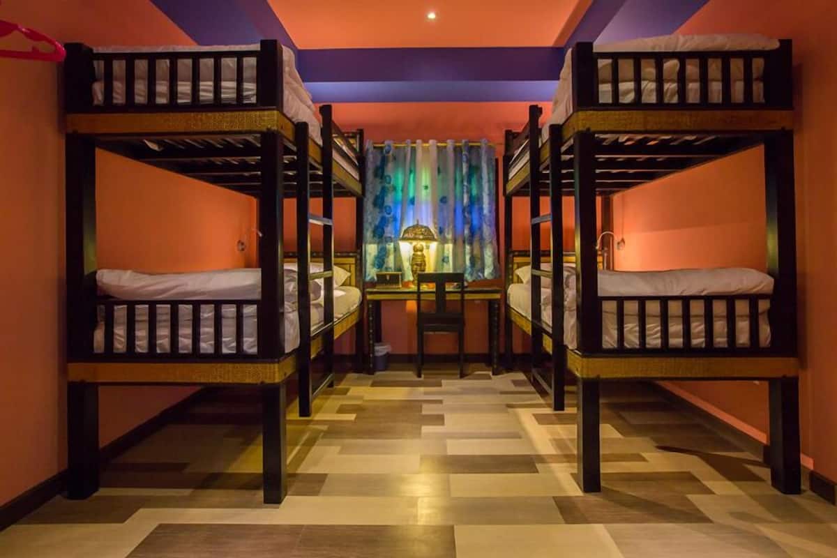A room with bunk beds, a desk, and a chair.