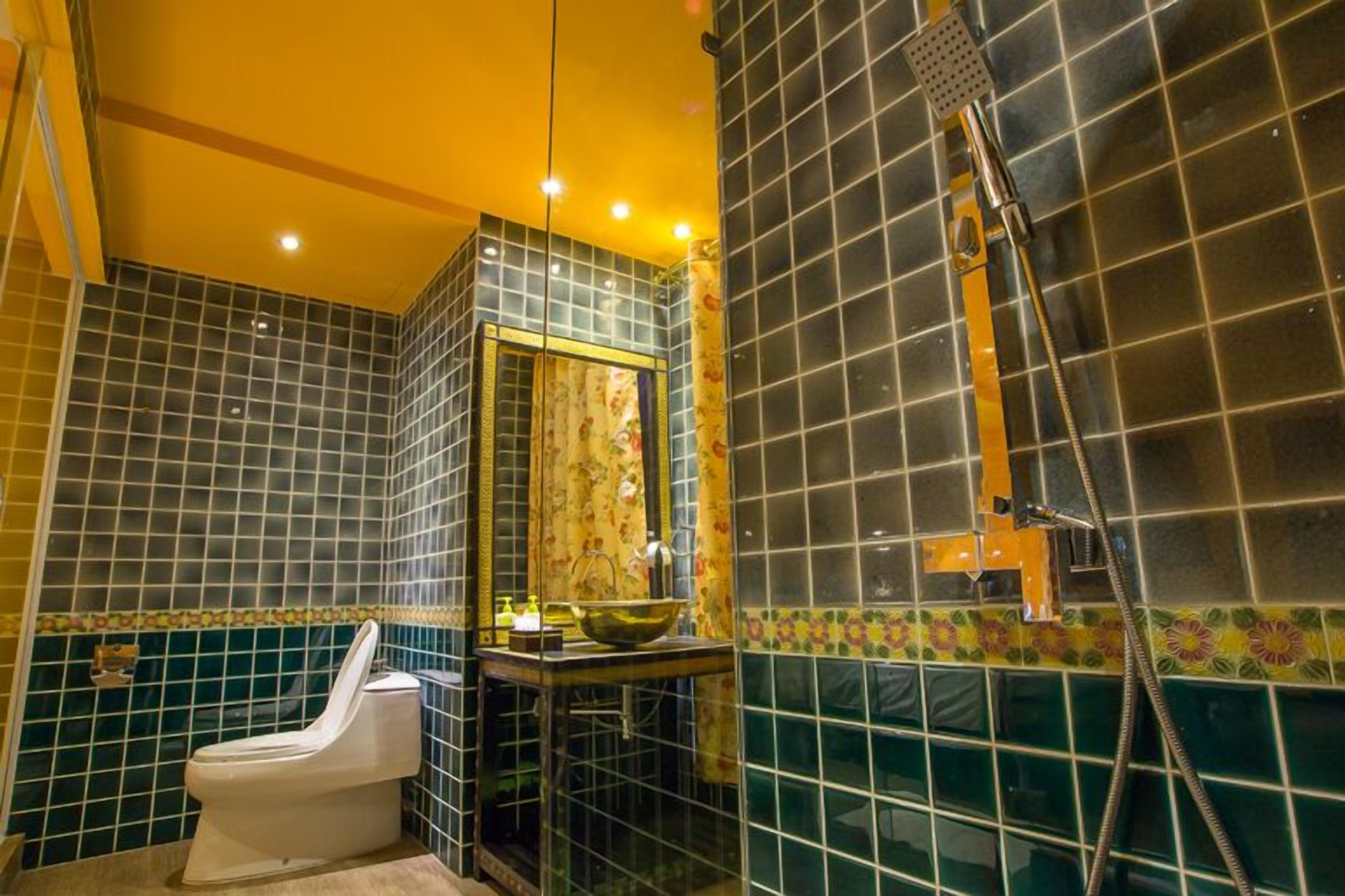 A bathroom with a toilet, a sink with a bowl, and a shower area.