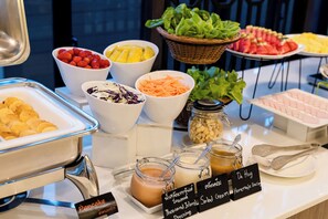 A buffet with various food items and labels indicating different dishes.