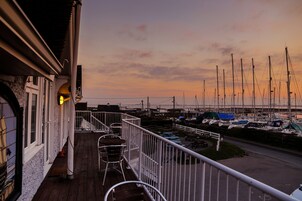 Un balcón con vista a un puerto deportivo al atardecer.