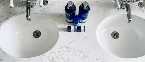 A bathroom with two white sinks and a marble countertop.