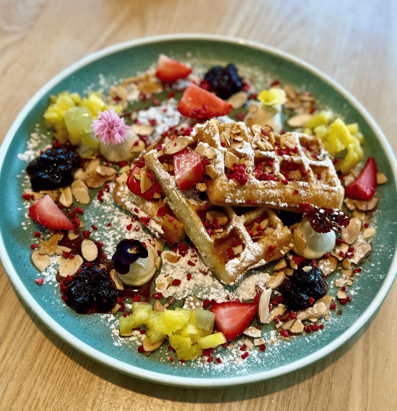 En tallrik med våfflor, frukt och nötter.