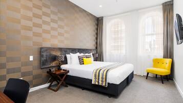 Una habitación de hotel moderna con una cama grande, un escritorio y una silla.
