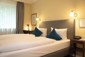 Restful retreat with a large bed, wooden nightstand, and framed artwork.