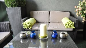 A glass-top table with a white candle, two blue glass vases, and two metallic ashtrays. - Hotel Altmünchen (Munich)