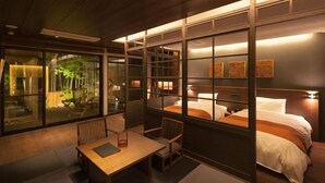 Ein modernes Hotelzimmer mit großem Fenster, einem Bett, einem Schreibtisch und einem Stuhl.