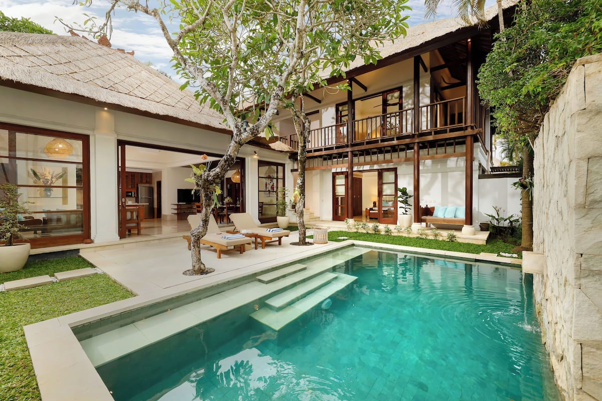 Ein modernes Haus mit Swimmingpool, Balkon und gepflegtem Garten.