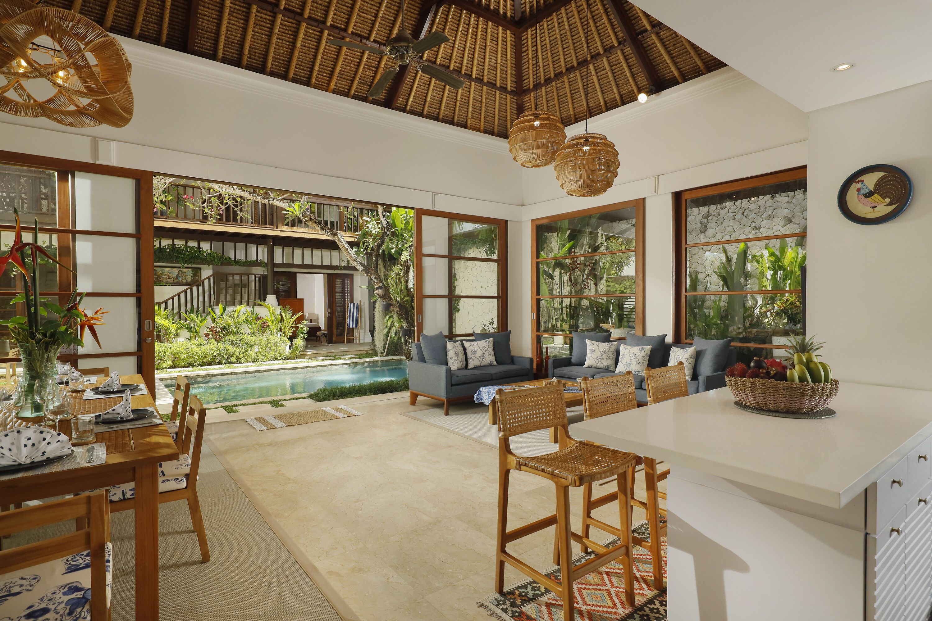 A spacious kitchen with a large island, built-in seating, and a view of a pool.
