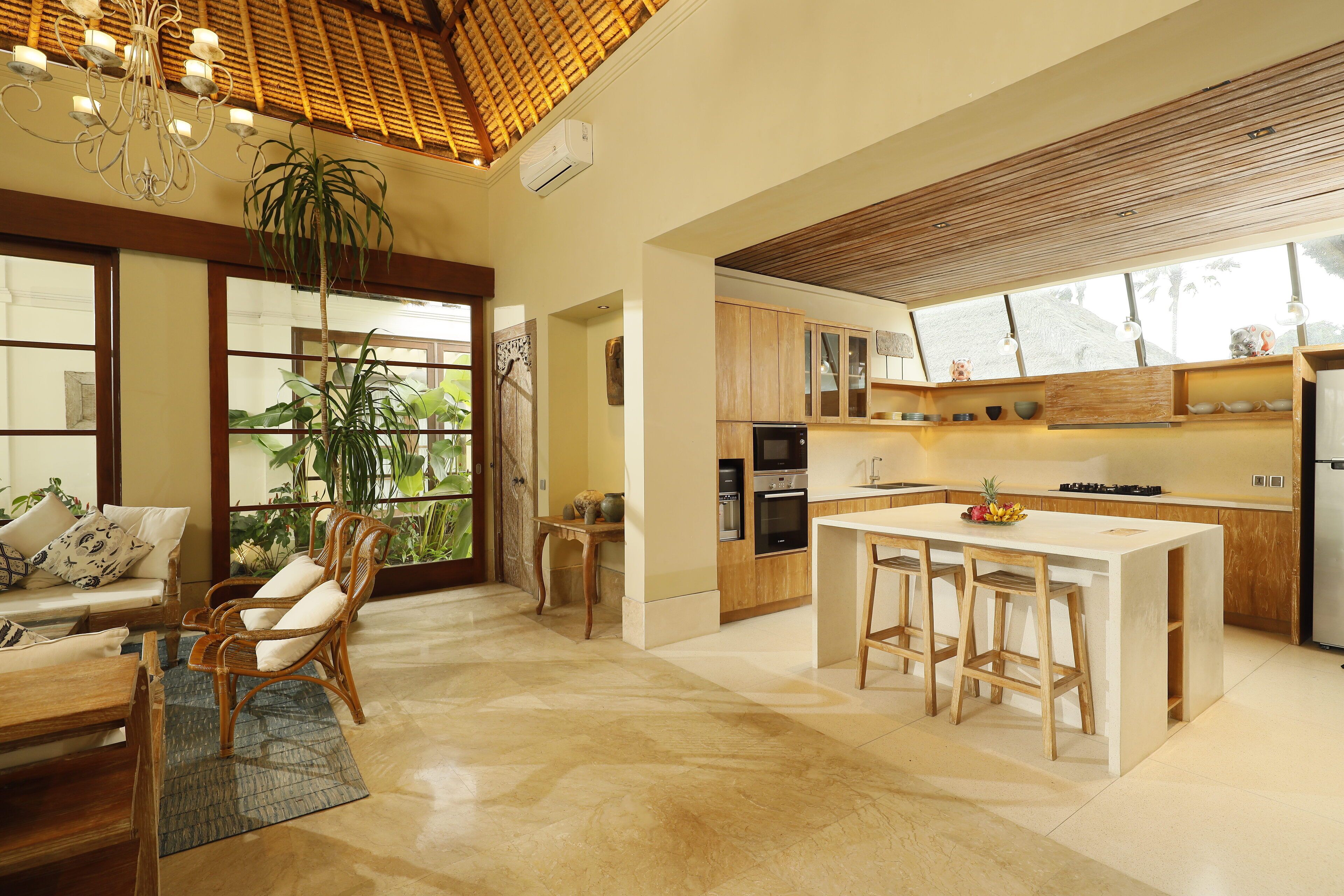 A spacious kitchen with a central island, wooden cabinets, and a large window providing natural light.