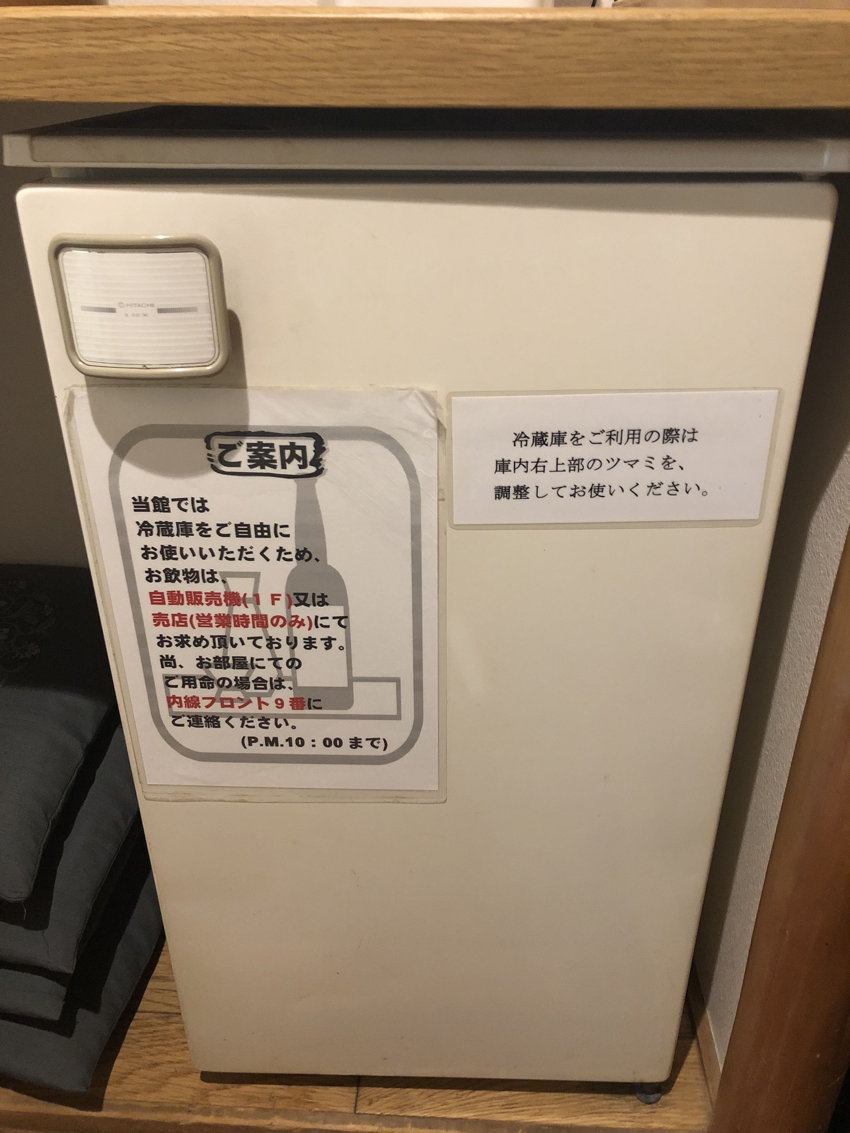 A refrigerator with a white interior and a small freezer compartment on top. There are two labels attached to the refrigerator, one on the left and one on the right.