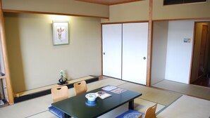 Une pièce de style japonais traditionnel, avec un sol recouvert de tatamis, une table basse et une porte coulissante.