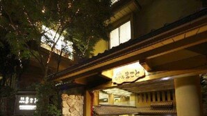 Un bâtiment traditionnel japonais, doté d’une façade en pierre et d’une enseigne au-dessus de l’entrée.