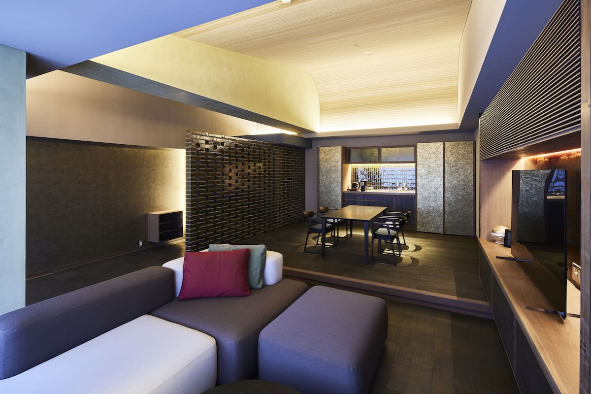 A modern interior with a seating area, a dining space, and a kitchen.