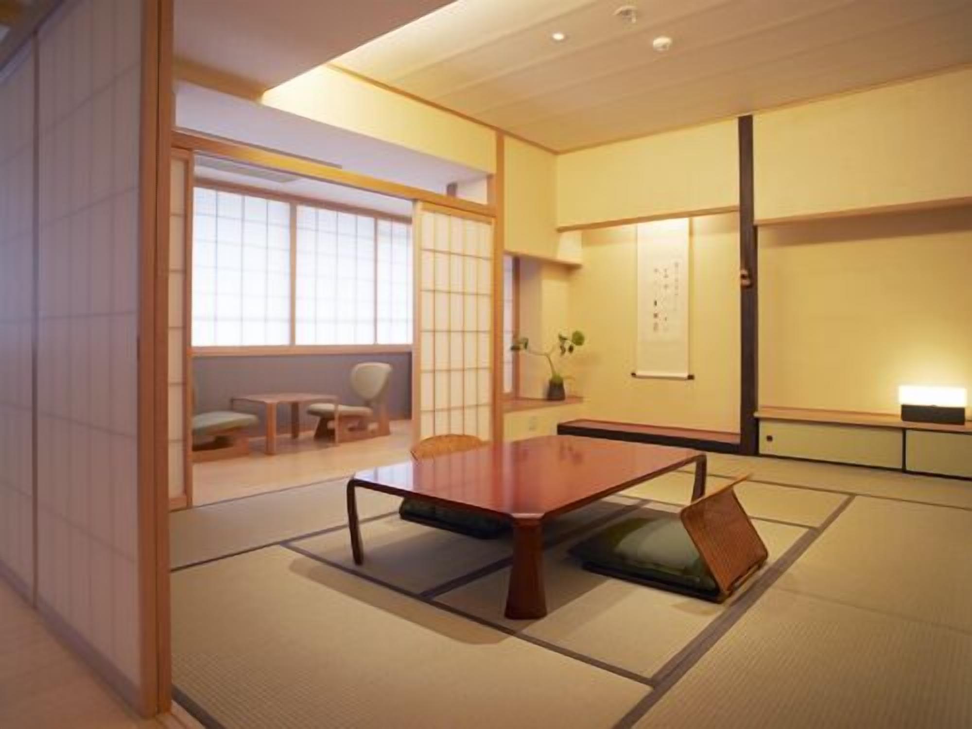 A traditional Japanese room with tatami flooring, a low wooden table, and sliding doors.