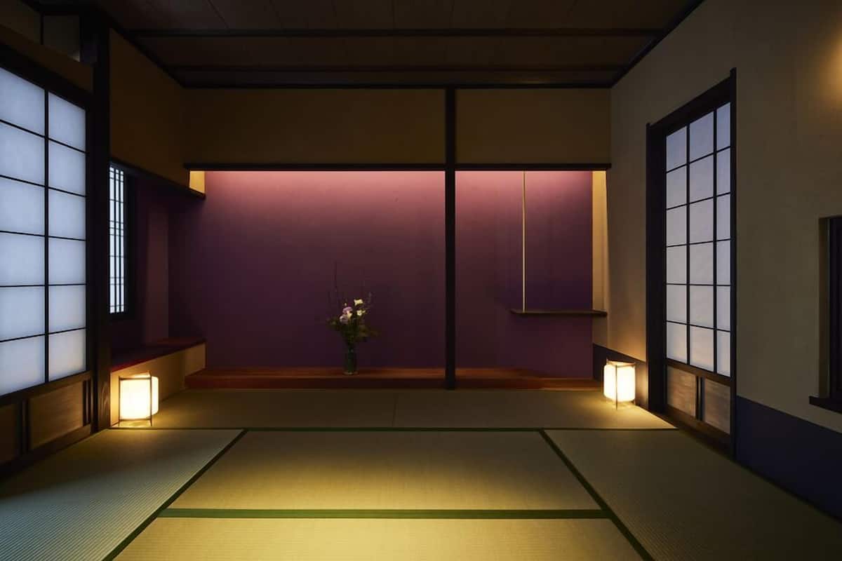 A traditional Japanese room with tatami flooring, sliding doors, and minimalistic decor.