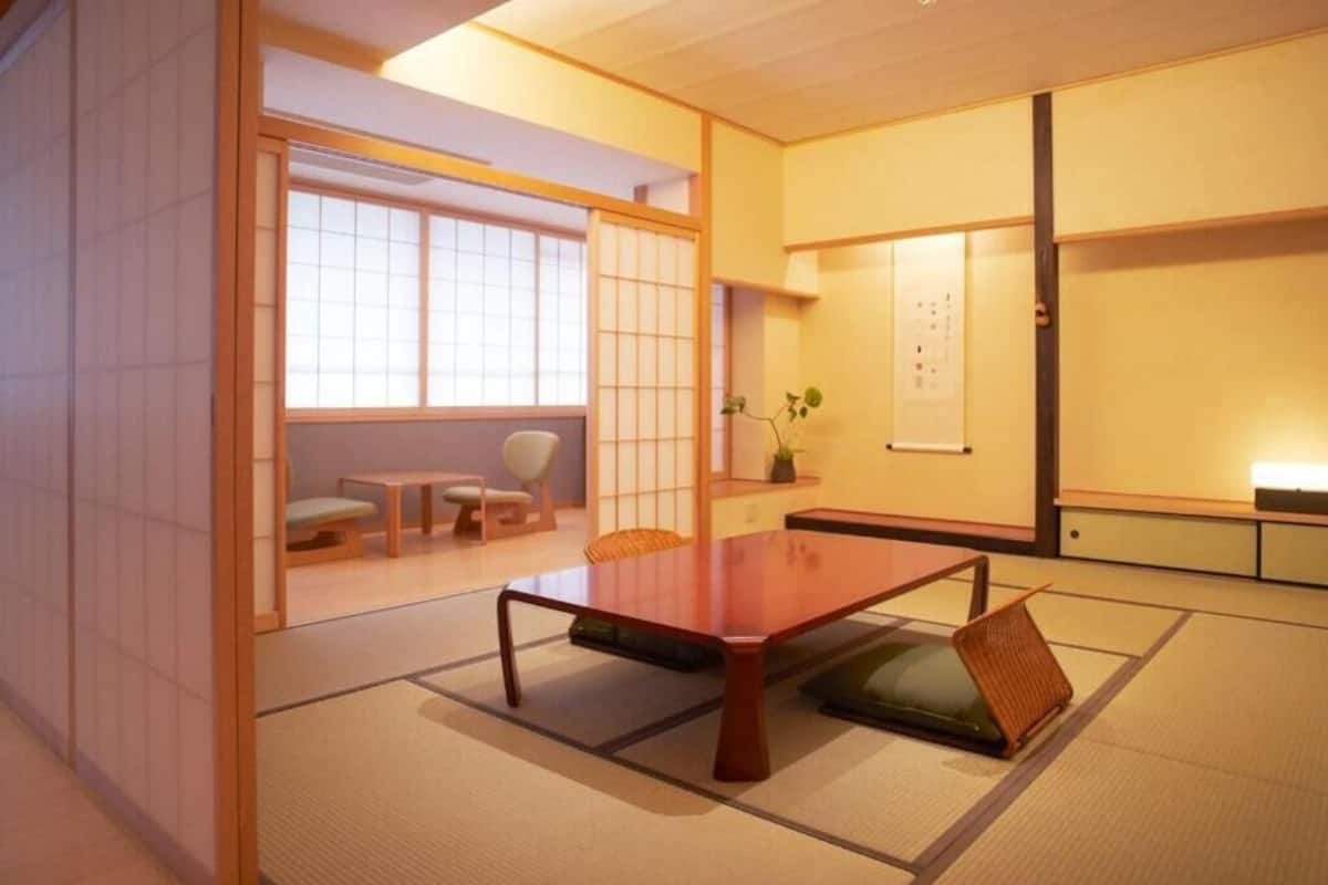 A traditional Japanese room with tatami flooring, a low wooden table, and sliding doors.